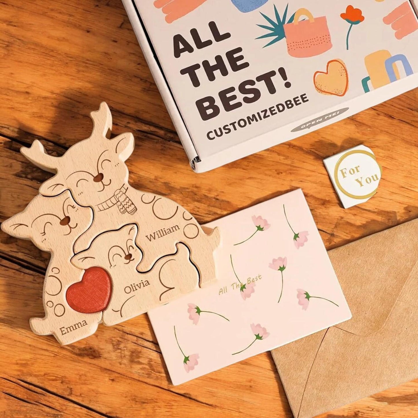 Wooden puzzle shaped like a family with personalized names on a wooden surface, next to a card and envelope.