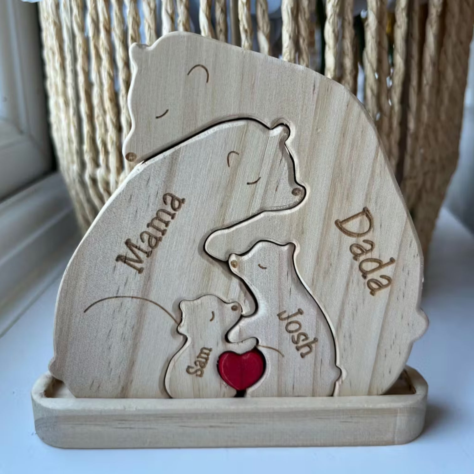 Wood Bear Family Puzzle With Stand and also custom engraved names of the family, on a white desk with a plant in the background