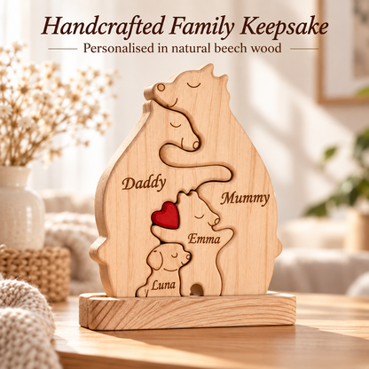 Personalized natural beech wood keepsake plaque shaped like a family of cats, engraved with the names 'Daddy', 'Mummy', and 'Emma' and a small red heart accent, displayed on a wooden surface in a softly lit home setting.
