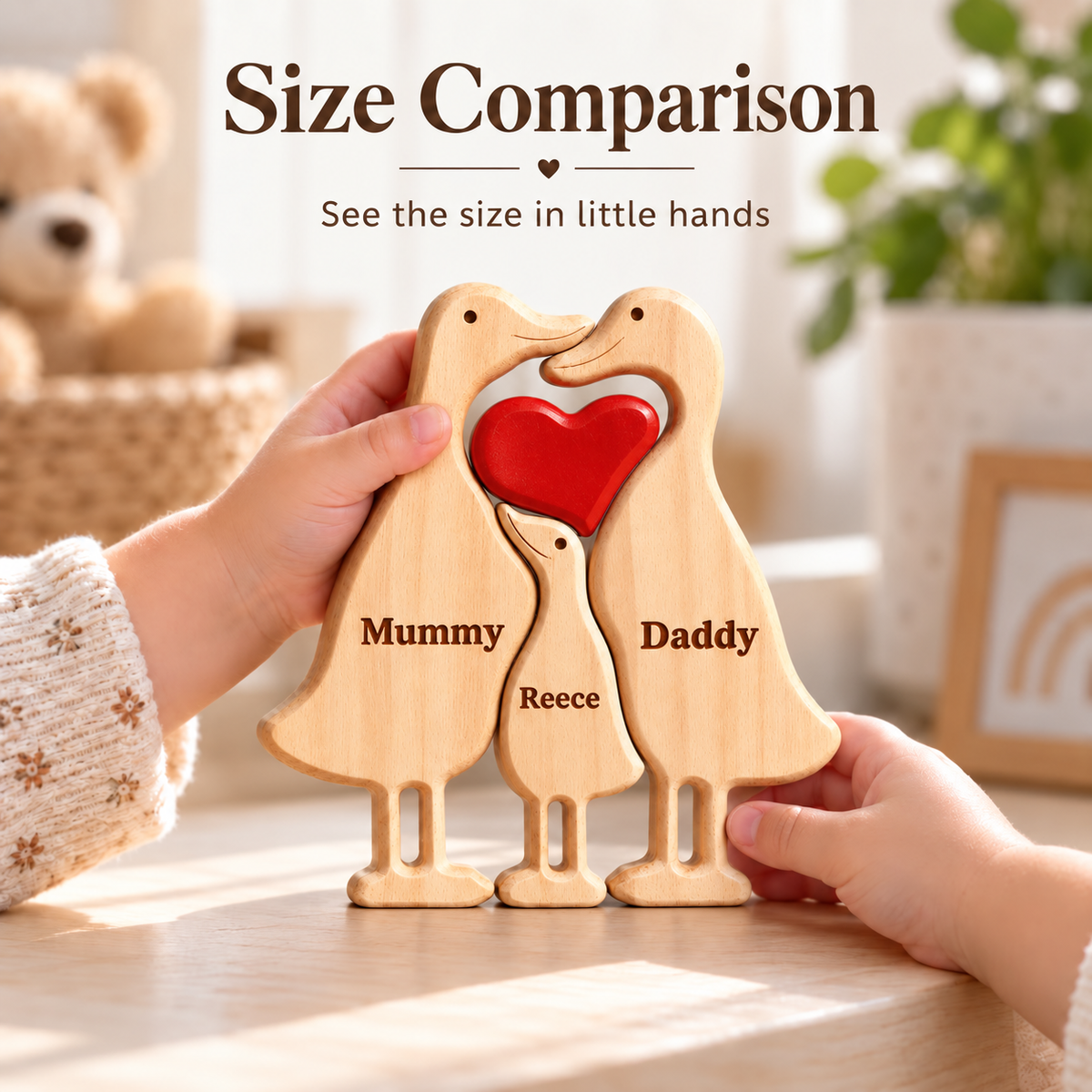 MyFamilyPuzzle personalised duck family puzzle held in a child's hands for size comparison. Two adult ducks and one duckling in solid beech wood are engraved Mummy, Daddy and Reece, with a red wooden heart between the parents. Shown on a sunlit table, this personalised wooden family keepsake makes a new mum gift, new baby gift, baby shower gift or personalised family gift.
