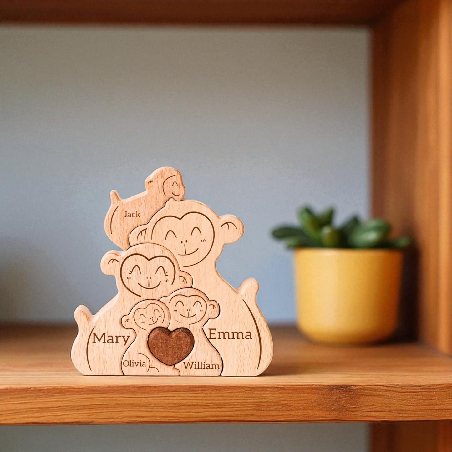 Personalised monkey family wooden puzzle for 5 people with custom engraved names on a wooden shelf.