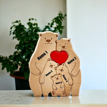 Wooden bear family figurine with a red heart, each bear has a name engraved on it, placed on a light surface with a blurred plant in the background.