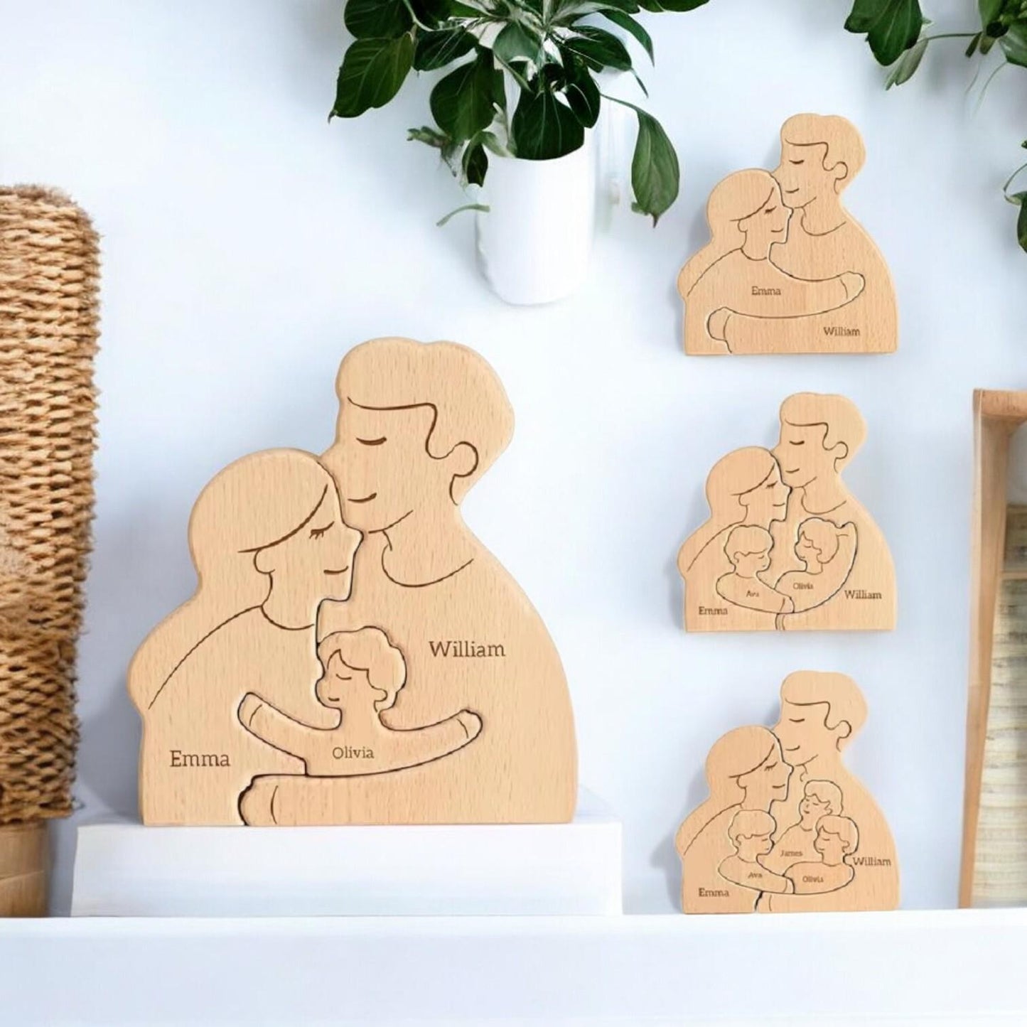Wooden family figures with engraved names on a white surface with plants in the background