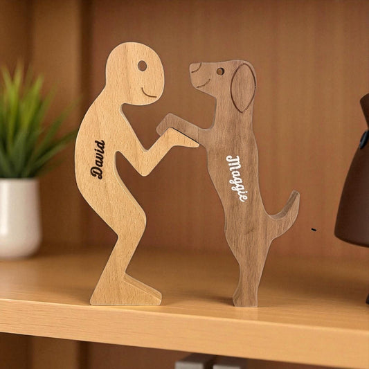 Wooden figures of a person and a dog holding hands on a wooden shelf.