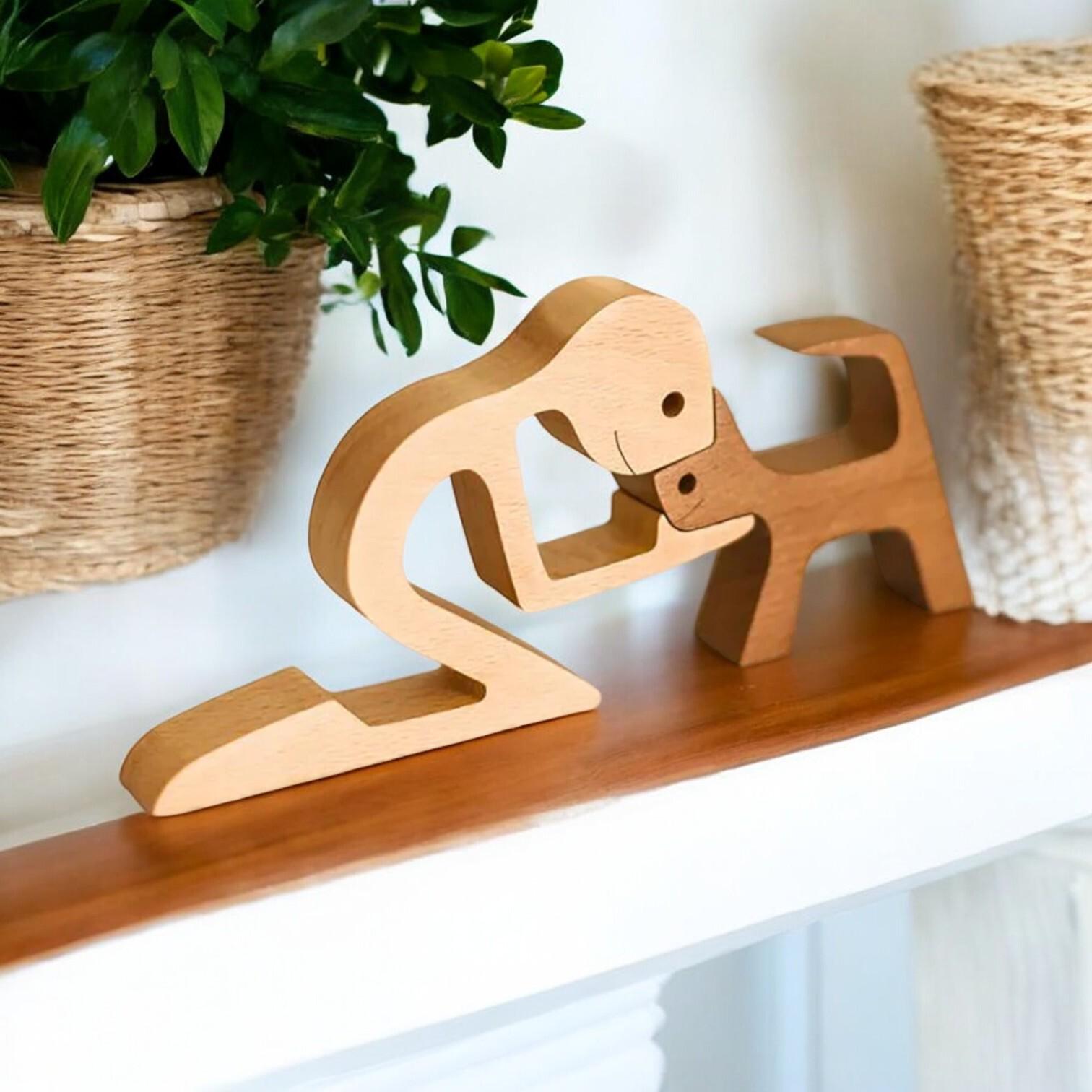 Wooden sculpture of a person holding a dog on a shelf with plants in the background