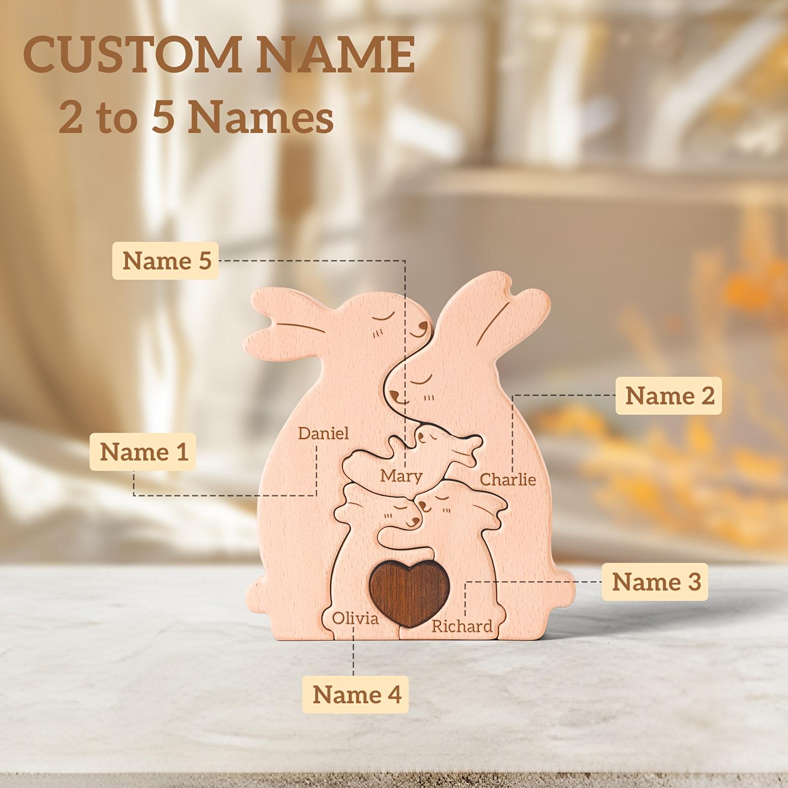 Wooden rabbit-shaped decoration with customizable names on a marble surface.