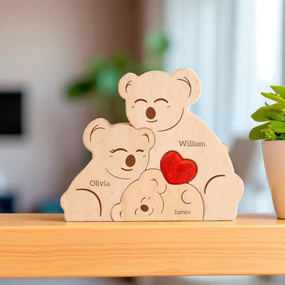 Wooden koala family with personalized names on a wooden surface.