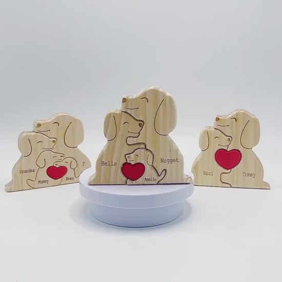 Wooden family puzzle of dog figurines with four pieces and a red heart, standing on a table with plants in the background.