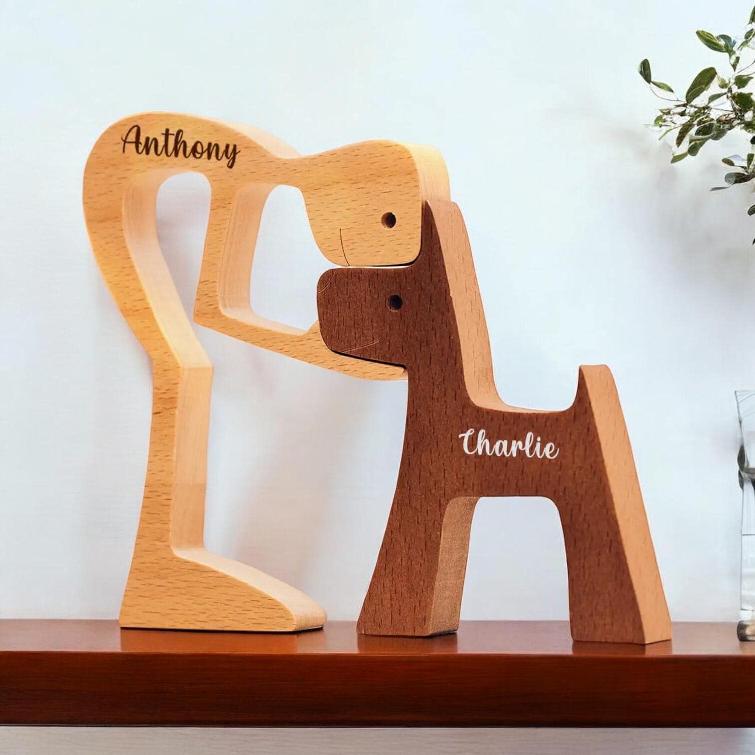 Close up of custom engraved names on wooden man and dog sculpture
